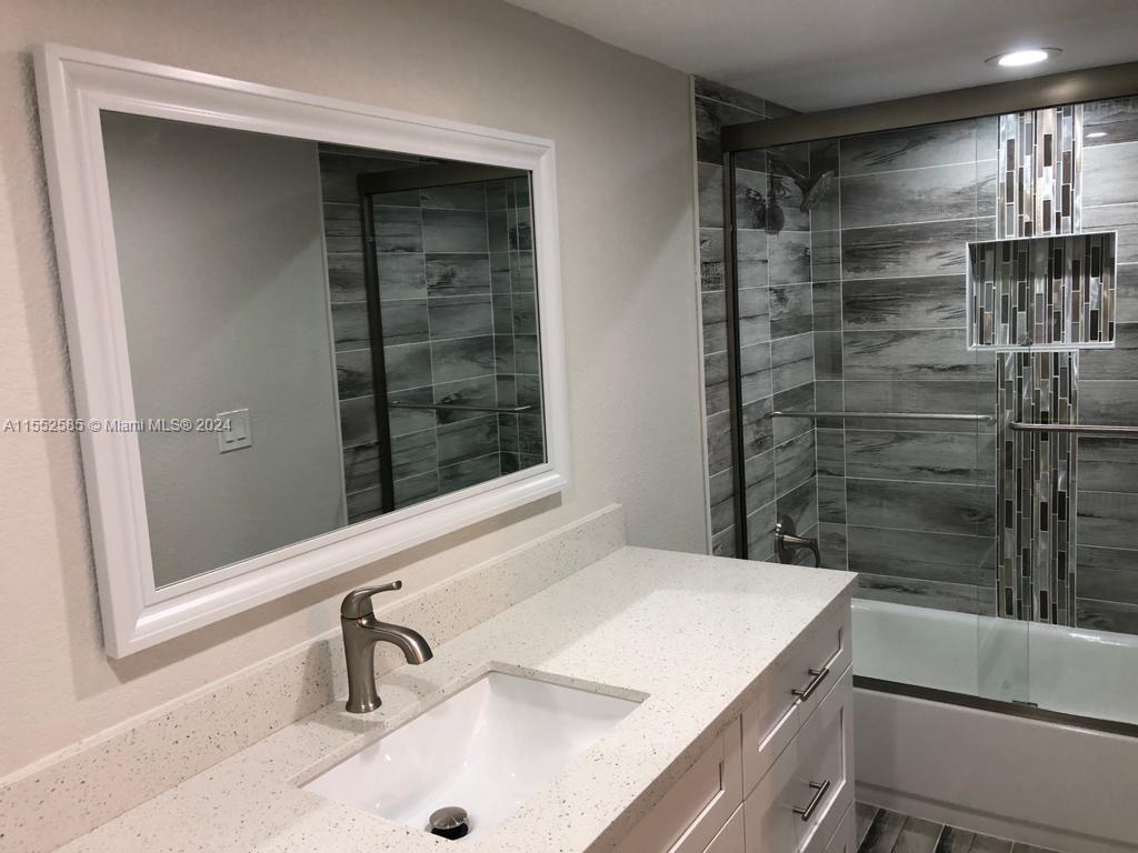 9273 Southwest 8th Street, Unit 310 Boca Raton, FL 33428 - Photo 9 of 21 a bathroom with a sink and a shower
