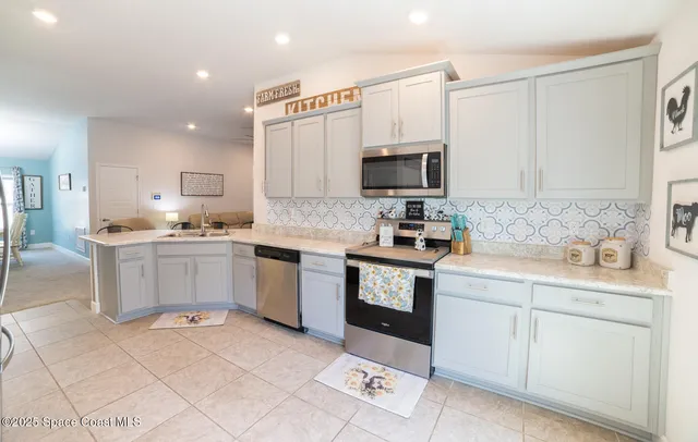 a kitchen with white cabinets and appliances