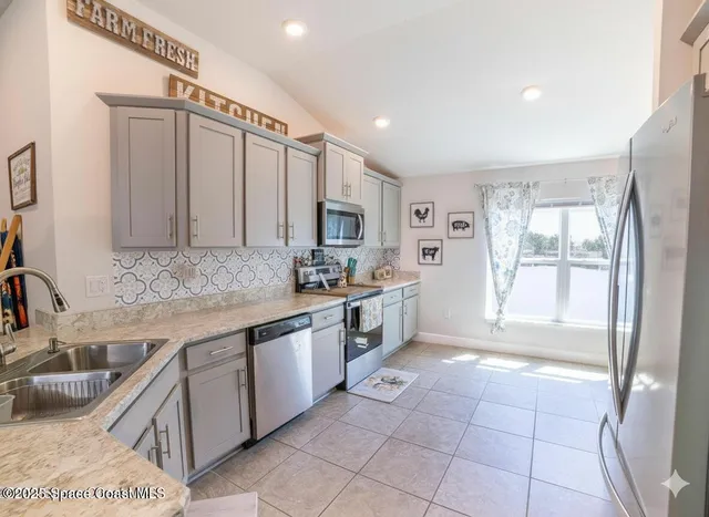 a large kitchen with kitchen island a sink stainless steel appliances and cabinets