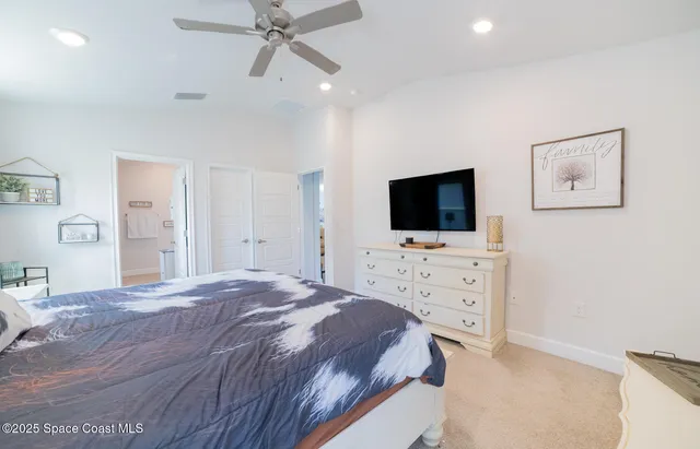 a bedroom with a flat screen tv on dresser and a flat screen tv