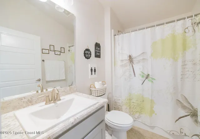 a bathroom with a sink a toilet and shower curtain