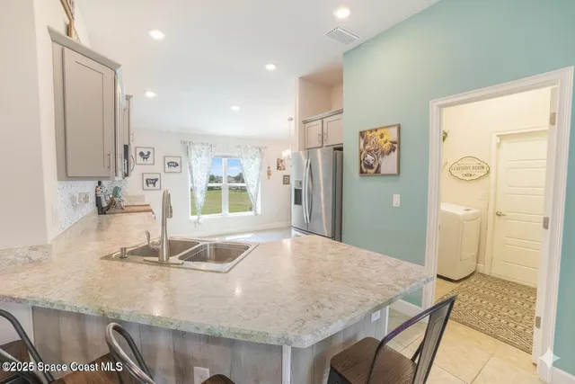 a kitchen with granite countertop a sink and a refrigerator