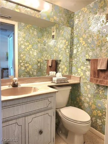 a bathroom with a toilet a sink and a mirror