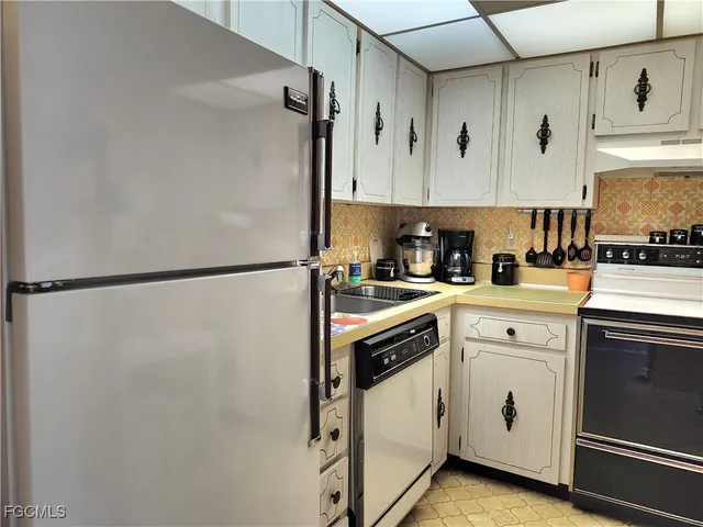 a kitchen with white cabinets and white appliances