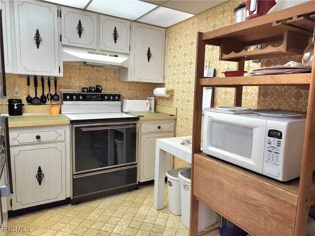 a kitchen with stainless steel appliances granite countertop a stove and white cabinets