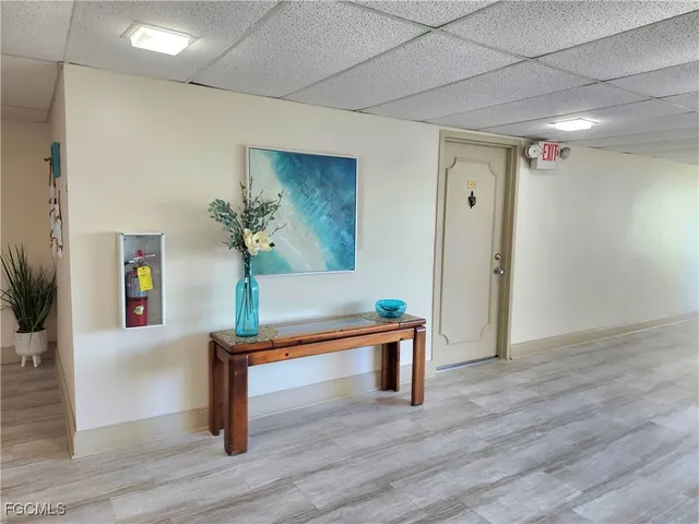a view of a hallway with wooden floor and furniture