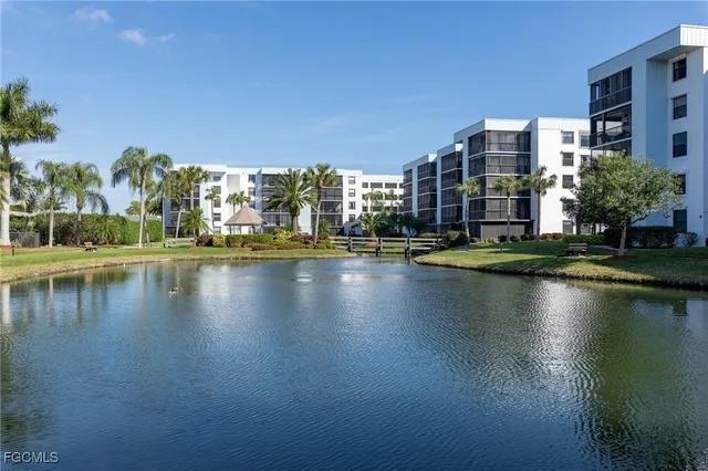 a view of building with lake view and trees in the background