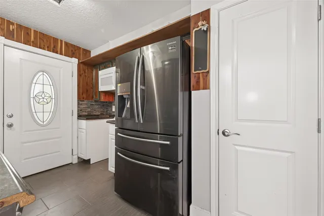 a view of kitchen with a refrigerator and cabinets