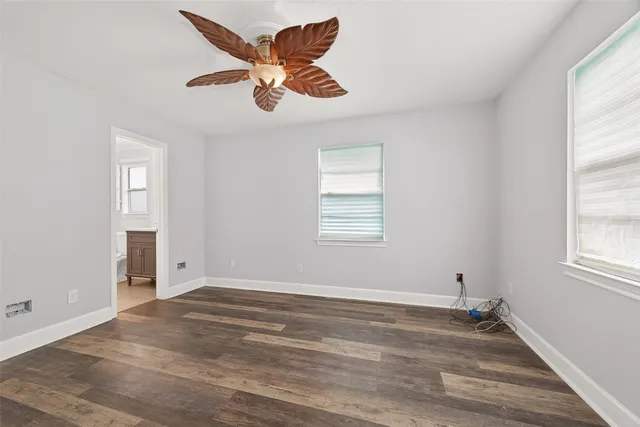 an empty room with a window and a ceiling fan