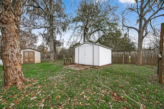 a view of a house with backyard and a tree