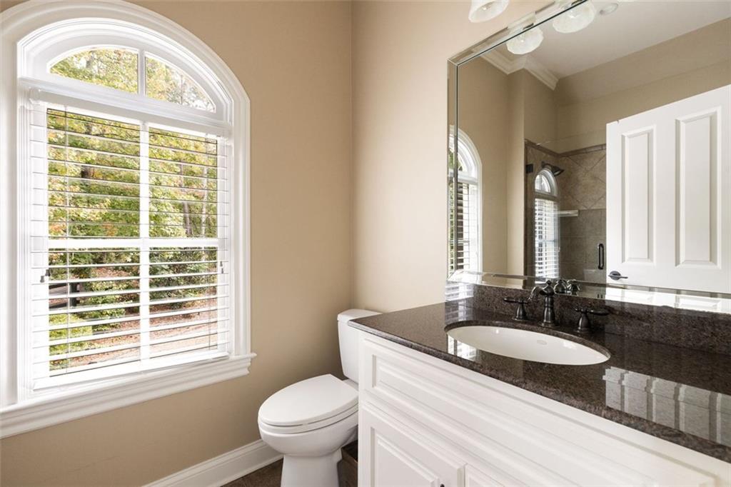 11015 Stroup Road Roswell, GA 30075 - Photo 58 of 113 a bathroom with a granite countertop window a sink and a mirror