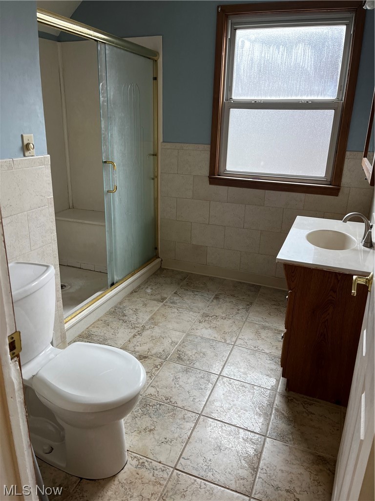 1610 Malasia Road Akron, OH 44305 - Photo 10 of 14 Bathroom featuring toilet, an enclosed shower, tile walls, tile floors, and vanity