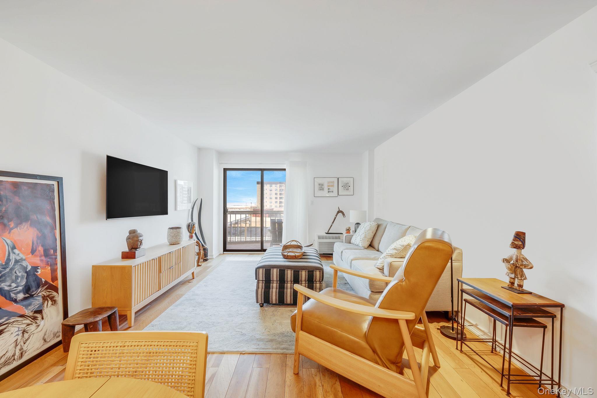 360 Shore Road, Unit 3H Long Beach, NY 11561 - Photo 11 of 23 a living room with furniture and a flat screen tv