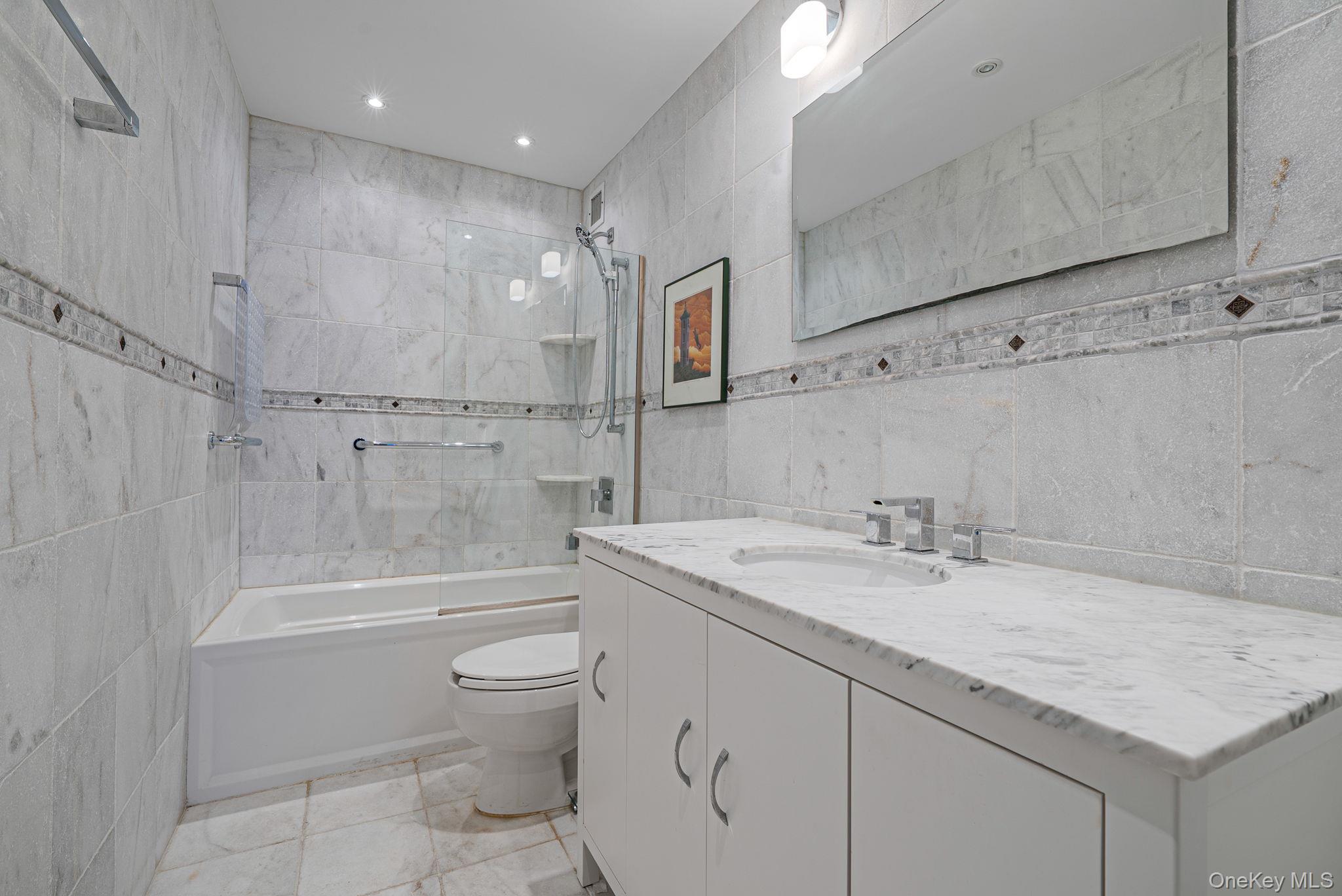 360 Shore Road, Unit 3H Long Beach, NY 11561 - Photo 22 of 23 a bathroom with a granite countertop sink a toilet and shower