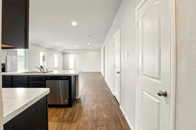 a open kitchen with a sink and dishwasher a oven with wooden floors