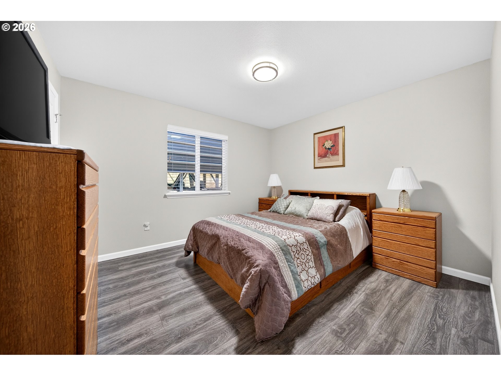 829 Jacobson Way Lakeside, OR 97449 - Photo 16 of 39 a bedroom with a bed and a dresser with wooden floor