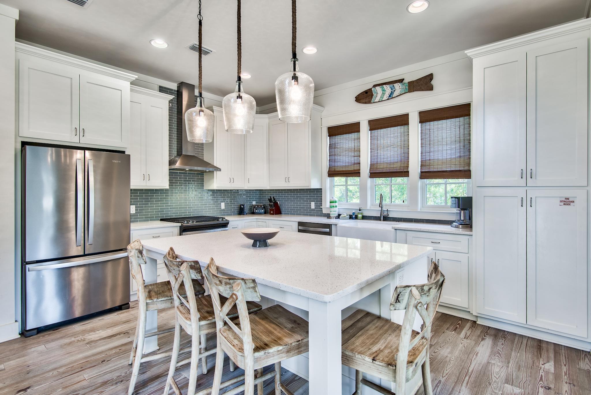 165 Sand Oaks Circle Santa Rosa Beach, FL 32459 - Photo 14 of 54 a kitchen with granite countertop a table chairs stainless steel appliances and wooden floor