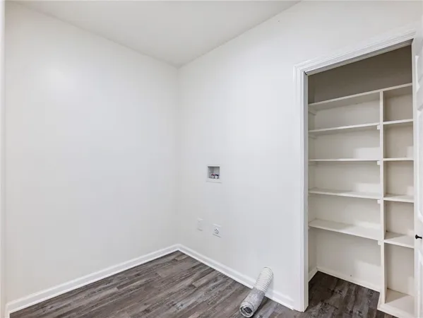 a view of a hallway with wooden floor and closet