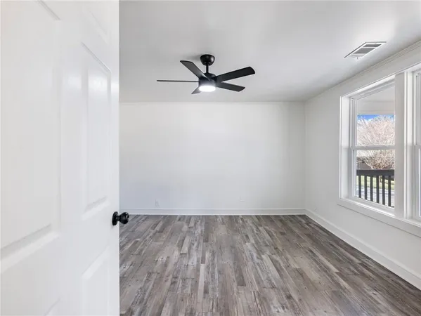 a view of empty room with wooden floor