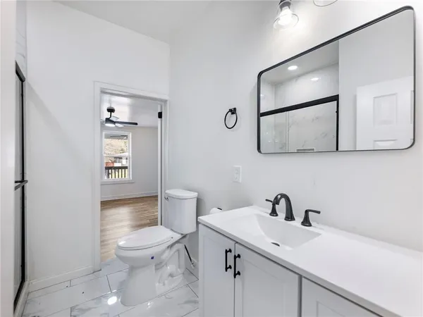 a bathroom with a toilet a window and tub