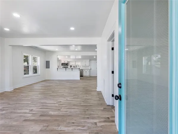 an empty room with wooden floor and windows