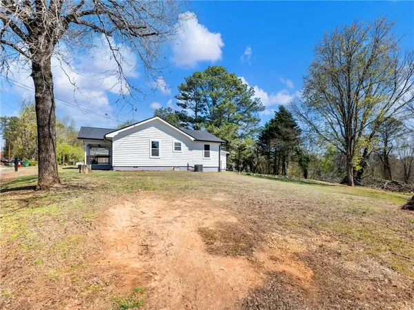 a large pool that has lawn chairs and a large tree