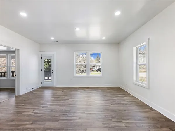 a view of empty room with wooden floor