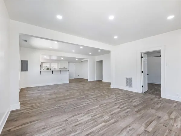 a view of empty room with wooden floor and windows