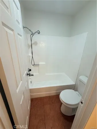a white toilet sitting next to a bath tub and a shower