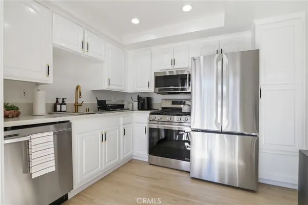 a kitchen with stainless steel appliances granite countertop a refrigerator sink and microwave