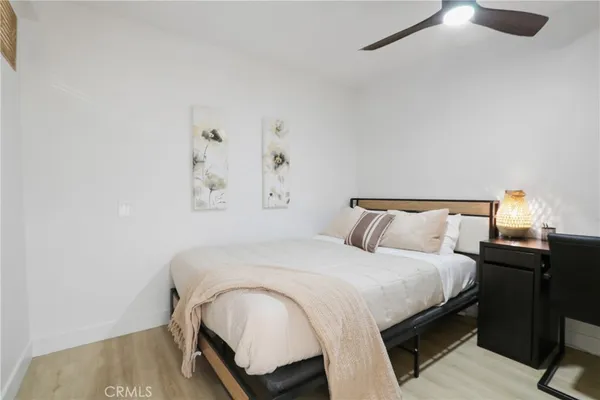 a bedroom with a bed and wooden floor