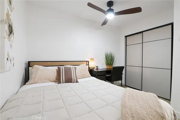 a bedroom with a bed and a potted plant