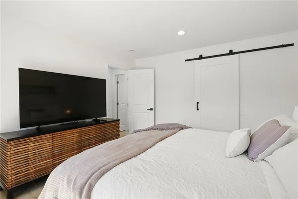 a bedroom with a bed and a flat screen tv
