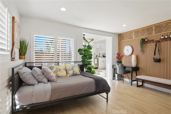 a spacious bedroom with a bed a chandelier and a window