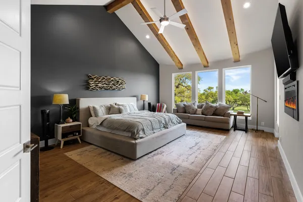 a bedroom with a bed couch tv and a window