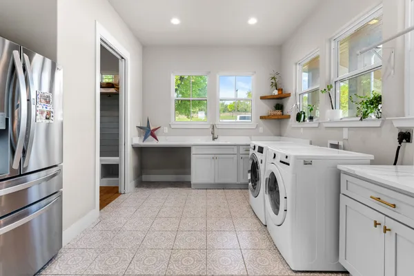 a utility room with cabinets washer and dryer