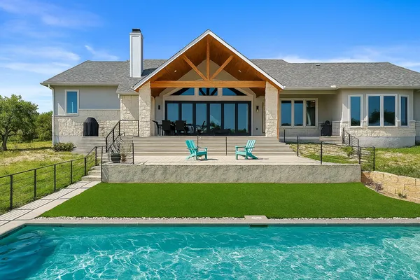 a front view of a house with swimming pool having outdoor seating