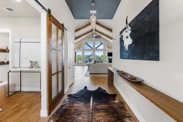 a view of a hallway with wooden floor and a living room