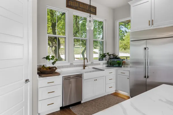 a kitchen with white cabinets and a window