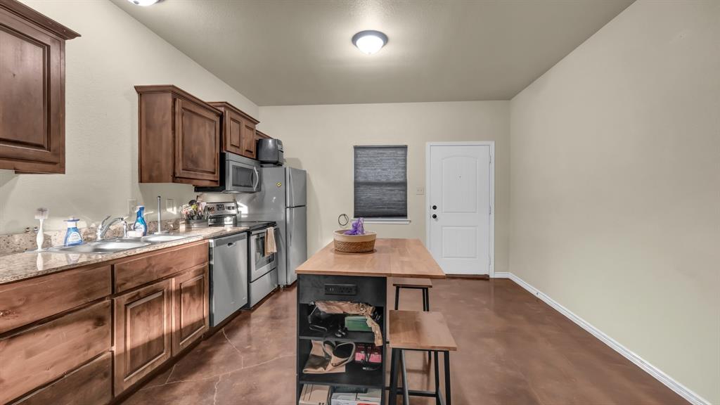 120 Bunkhouse Road Stephenville, TX 76401 - Photo 23 of 40 a kitchen with a sink stove and cabinets