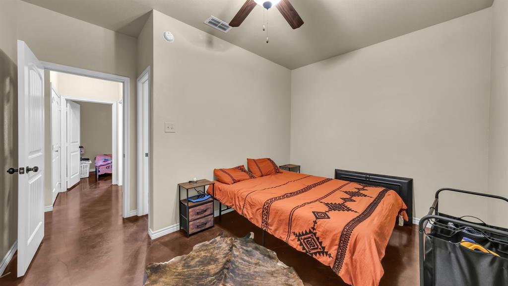 120 Bunkhouse Road Stephenville, TX 76401 - Photo 29 of 40 a bedroom with a bed and a chandelier