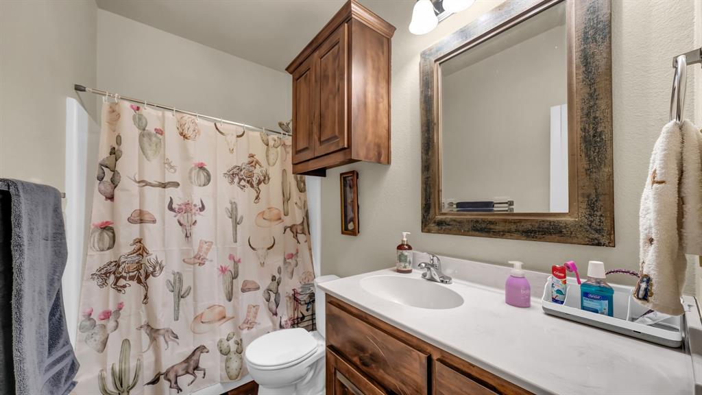 120 Bunkhouse Road Stephenville, TX 76401 - Photo 31 of 40 a bathroom with a sink toilet vanity and shower