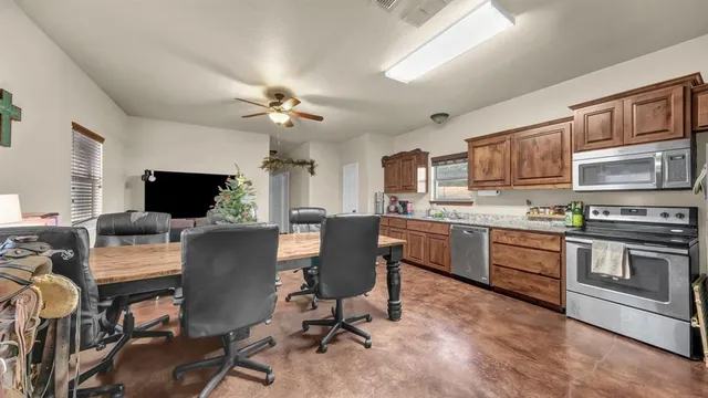 a living room with stainless steel appliances kitchen island granite countertop furniture and a kitchen view