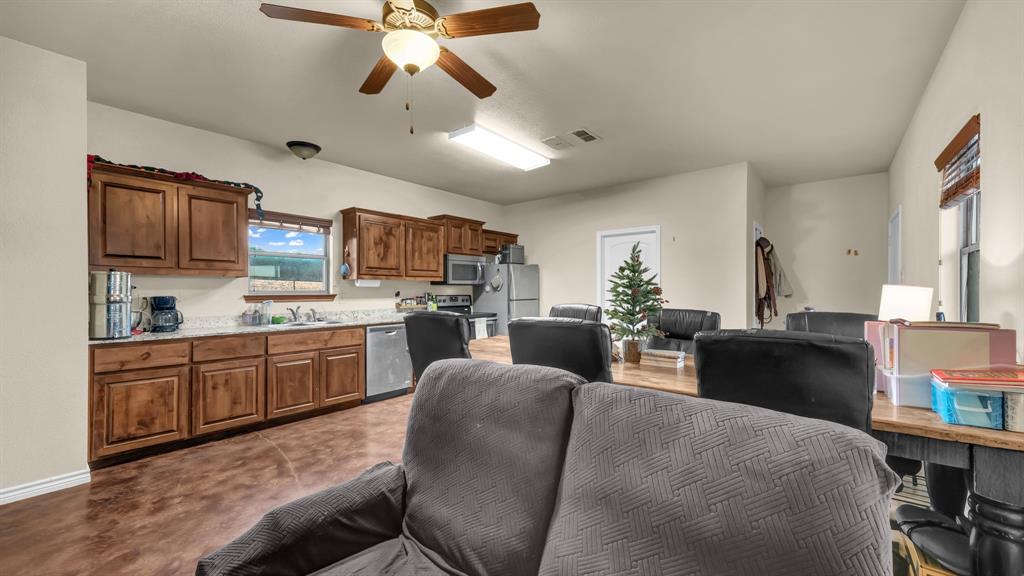 120 Bunkhouse Road Stephenville, TX 76401 - Photo 36 of 40 a living room with stainless steel appliances kitchen island granite countertop furniture and a kitchen view