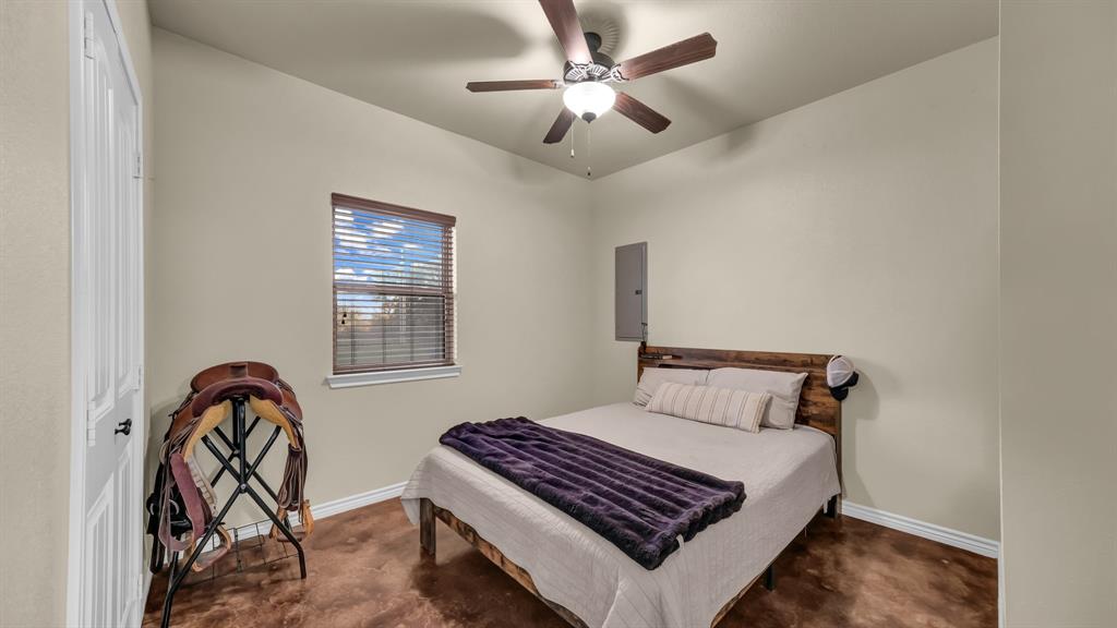 120 Bunkhouse Road Stephenville, TX 76401 - Photo 38 of 40 a bedroom with a bed and a chandelier