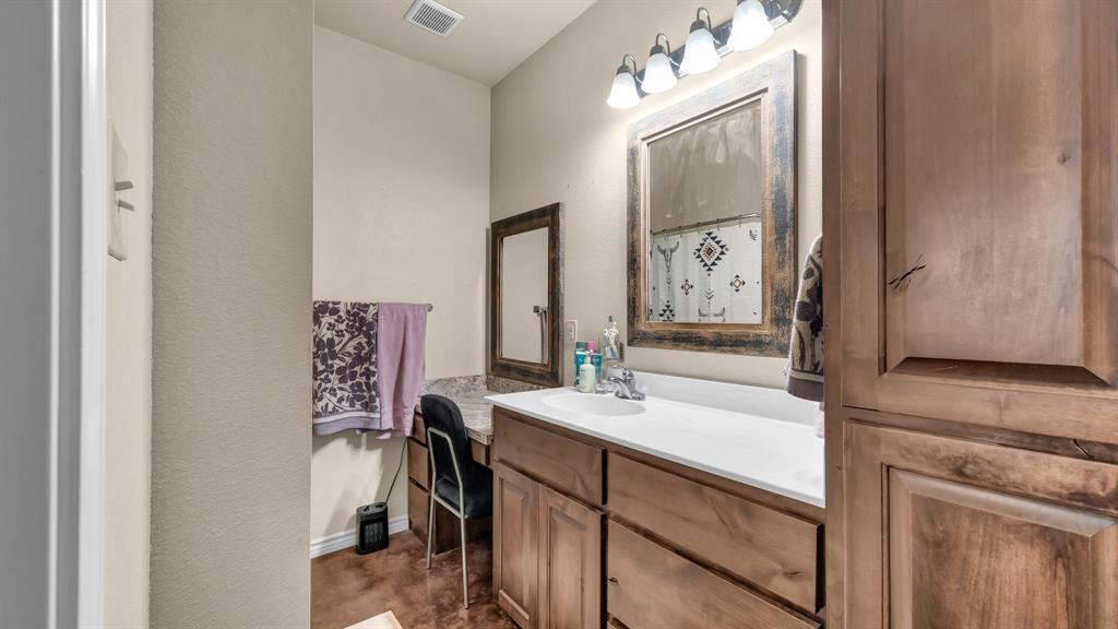 120 Bunkhouse Road Stephenville, TX 76401 - Photo 39 of 40 a bathroom with a sink vanity and a mirror