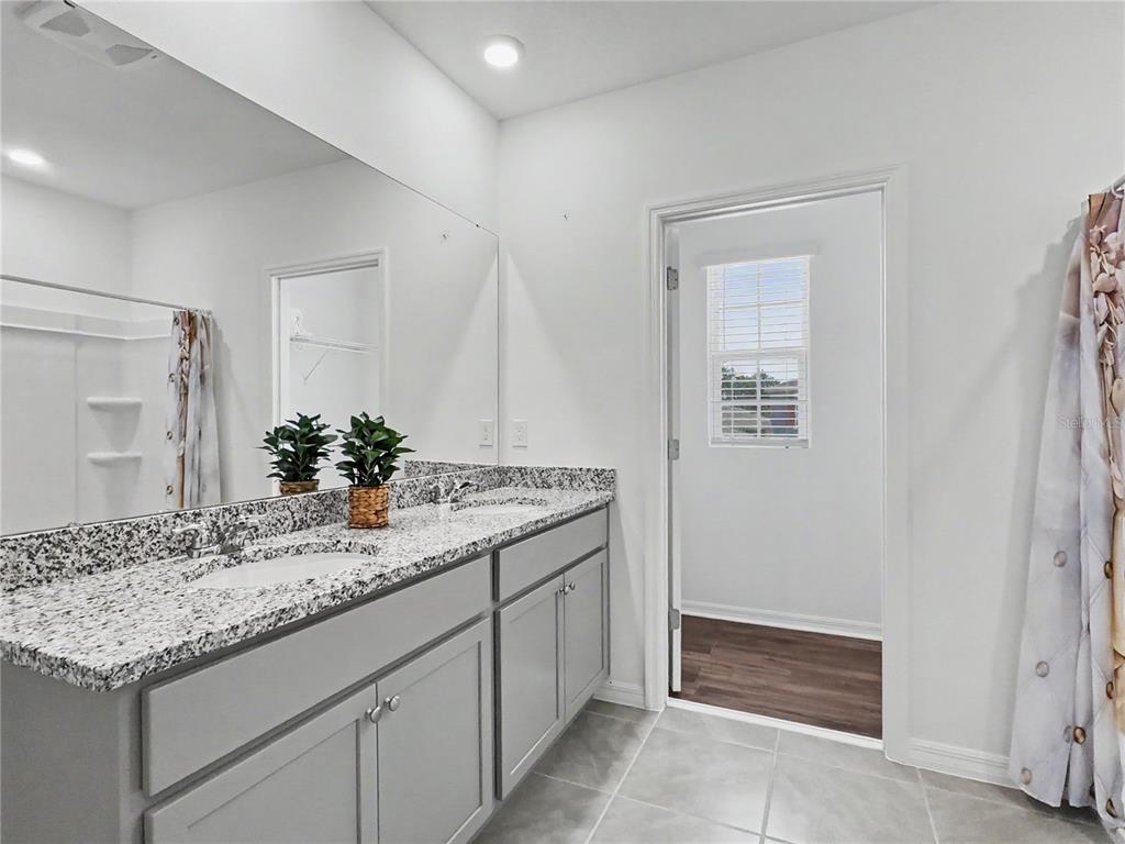 2085 Doe Run Drive Davenport, FL 33837 - Photo 31 of 44 a bathroom with a granite countertop sink and a mirror
