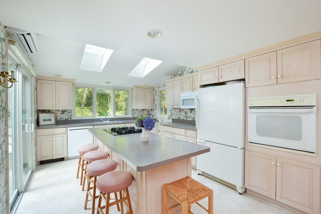57 Two Ponds Road Falmouth, MA 02540 - Photo 17 of 42 a kitchen with refrigerator cabinets dining table and chairs