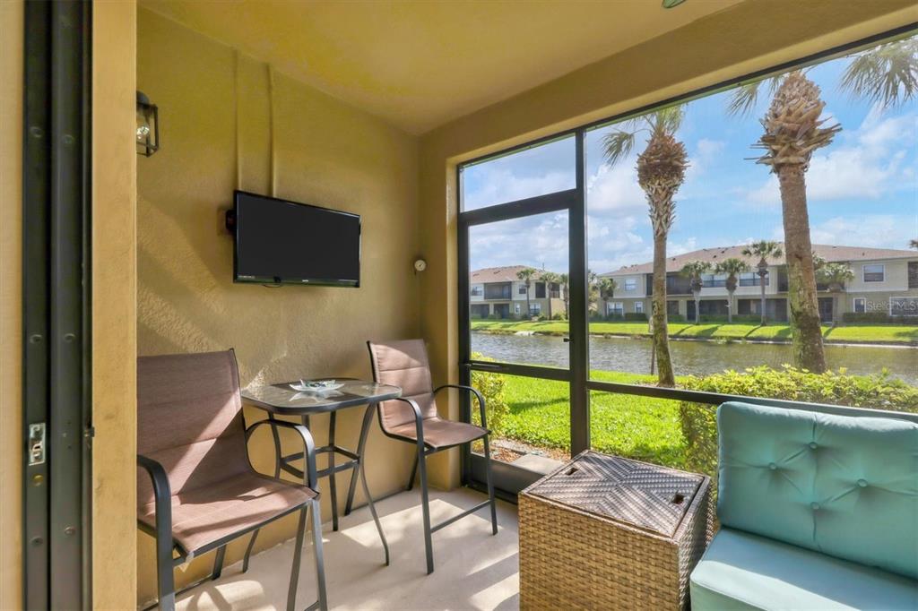 4174 Overture Circle, Unit 519 Bradenton, FL 34209 - Photo 13 of 53 a living room with furniture tv and a floor to ceiling window