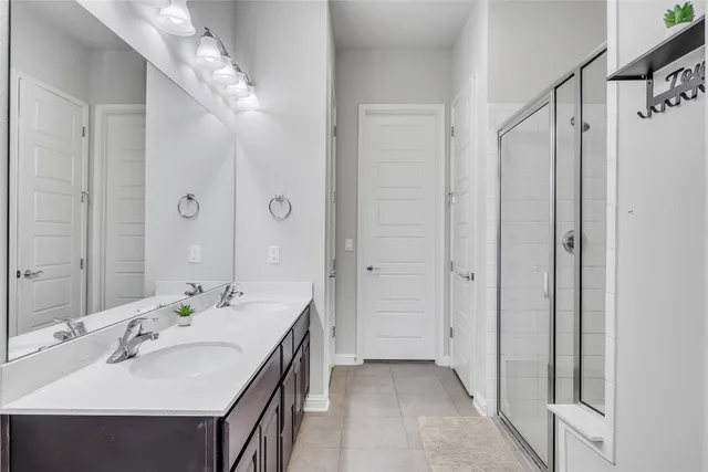 a en suite bathroom with a double vanity sink and mirror